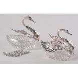 A pair of graduated, cut glass swan bowls with silver hinged wings and neck.