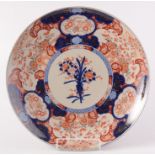 A large Japanese Imari porcelain charger, with a central vase of flowers,