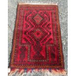 An Afghan prayer rug, the red field with two linked serrated medallions, 123 x 82cm.