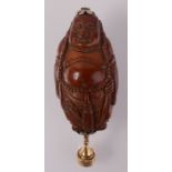 A Chinese coquilla nut buddha carved pendant with gold drop.
