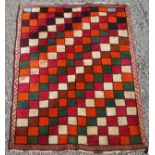 A south west Persian rug decorated with rows of polychrome squares, some enclosing script,