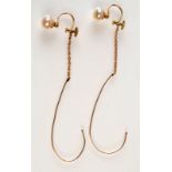 A pair of gold and pearl screw on earrings with gold safety hooks.