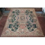 An Abusson needlepoint carpet, the green field with a large central floral decorated medallion,
