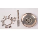 A silver charm bracelet, a silver ingot and a silver mounted armada dish.