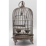 A metal bird cage of typical circular form on three splayed feet, height 30cm.