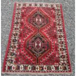 A Shiraz rug, south west Persia, the red field with two linked serrated medallions,