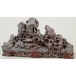 A Chinese soapstone carving of pagodas in a mountainous scene, length 20cm.