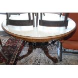 A Victorian oval walnut snap top dining table on four turned and carved supports,
