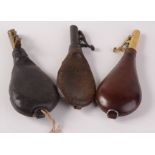 Three leather shot flasks, one inscribed Dixon & Son, length 21.5cm.