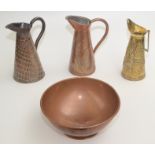 A copper footed bowl, 31cm, two copper jugs and a brass jug.