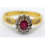 An 18ct gold diamond and ruby cluster ring with diamond shoulders.