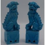 A pair of Chinese turquoise porcelain dogs of fo, each seated on a plinth base, height 20cm.