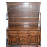 A pine dresser in George III style and possibly of the period, the upper section with open shelf,