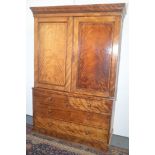 A linen press, the upper section with panel doors, the base with two short and two long drawers.