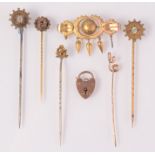 Gold and other stick pins, a gold padlock clasp and a gilt brooch.