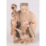 A Chinese part coloured carved ivory netsuke, an elderly gentleman wearing a robe,