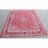 A Mashad Persian carpet, the red ground with central polychrome, lobed pole medallion,