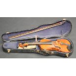 A violin labelled 'Copy of Antonius Stradivarius' cased with a bow, length of back 36cm.