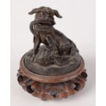 A Chinese bronze figure of a seated kylin, on a carved hardwood stand, total height 13cm.