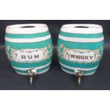 A pair of pottery spirit barrels inscribed 'I.Whisky' and 'Rum', each with a brass tap, height 33cm.