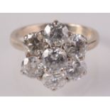 An impressive diamond seven stone flowerhead cluster ring set in 18ct gold,