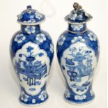 Two Chinese blue and white baluster vases and covers decorated with floral panels on a foliated