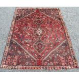A Shiraz Persian carpet with a polychrome triple linked medallion, guls and animals,