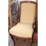 A Victorian walnut salon armchair upholstered in pale yellow fabric on turned legs,