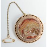 A Victorian gold mounted agate disc brooch with beaded border.