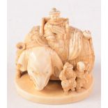 A Japanese ivory netsuke carved as an elephant standing four square and mounted with a throne style