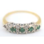 An 18ct gold ring set diamonds and emeralds, one emerald is missing.