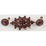 A pair of garnet earrings and a garnet brooch.