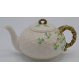 A Belleek porcelain teapot, with naturalistic handle, 2nd period black mark to base, height 11cm.