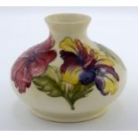 A Moorcroft ovoid squat vase, decorated with flowers on a cream ground, height 10.5cm.