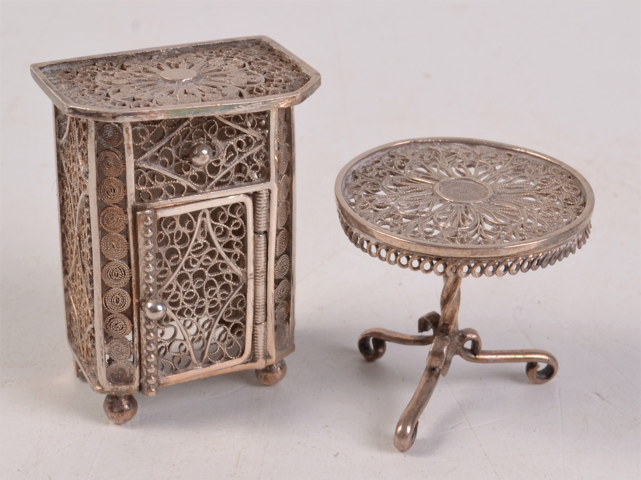 A 19th century miniature silver filigree tripod table and a similar cabinet.