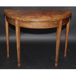 A George III crossbanded, half round fold top card table on square section tapering legs.