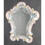 A Venetian glass dressing table mirror, the shaped border with gilt coloured flowerheads,