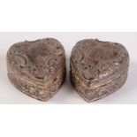 A pair of late Victorian embossed silver heart shaped boxes with hinged lids and gilt interiors,