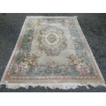 A large Chinese carpet with a polychrome floral medallion within a similar border, 370 x 277cm.