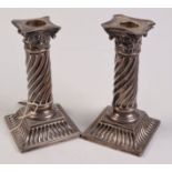 A pair of spiral fluted, filled silver late Victorian candlesticks, height 15cm, one missing nozzle.