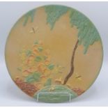 An Art Deco pottery charger, decorated with a woodland scene, diameter 30.5cm.