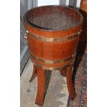 A teak standing jardiniere with brass banding and brass lion mask handles.