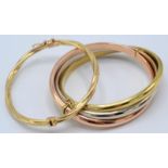 A 9ct gold tri-colour crossover bangle, together with a 9ct gold twist bangle.
