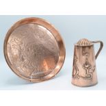 An Arts and Crafts J.S & S copper jug, height 16.5cm and a circular copper tray, diameter 25.5cm.