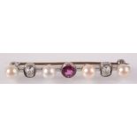 A bar brooch set two cushion cut diamonds, a central ruby and four pearls.