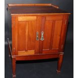 An Edwardian mahogany small cupboard with a pair of panelled doors on square section tapering legs,