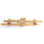 A 9ct gold bar brooch mounted with a pearl set swallow flanked by red stones.