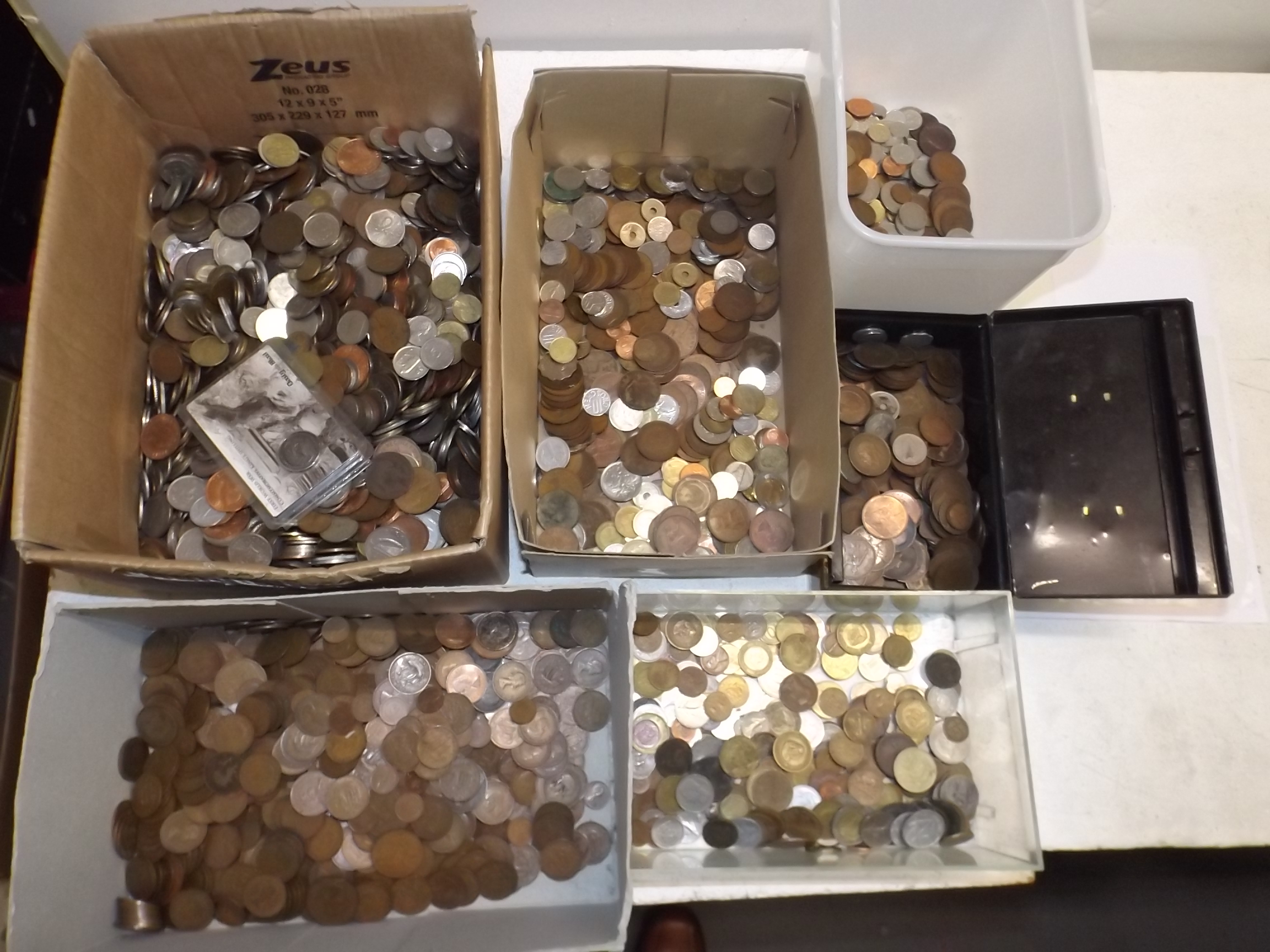 A heavy accumulation of world coins in five boxes and a cash tin.