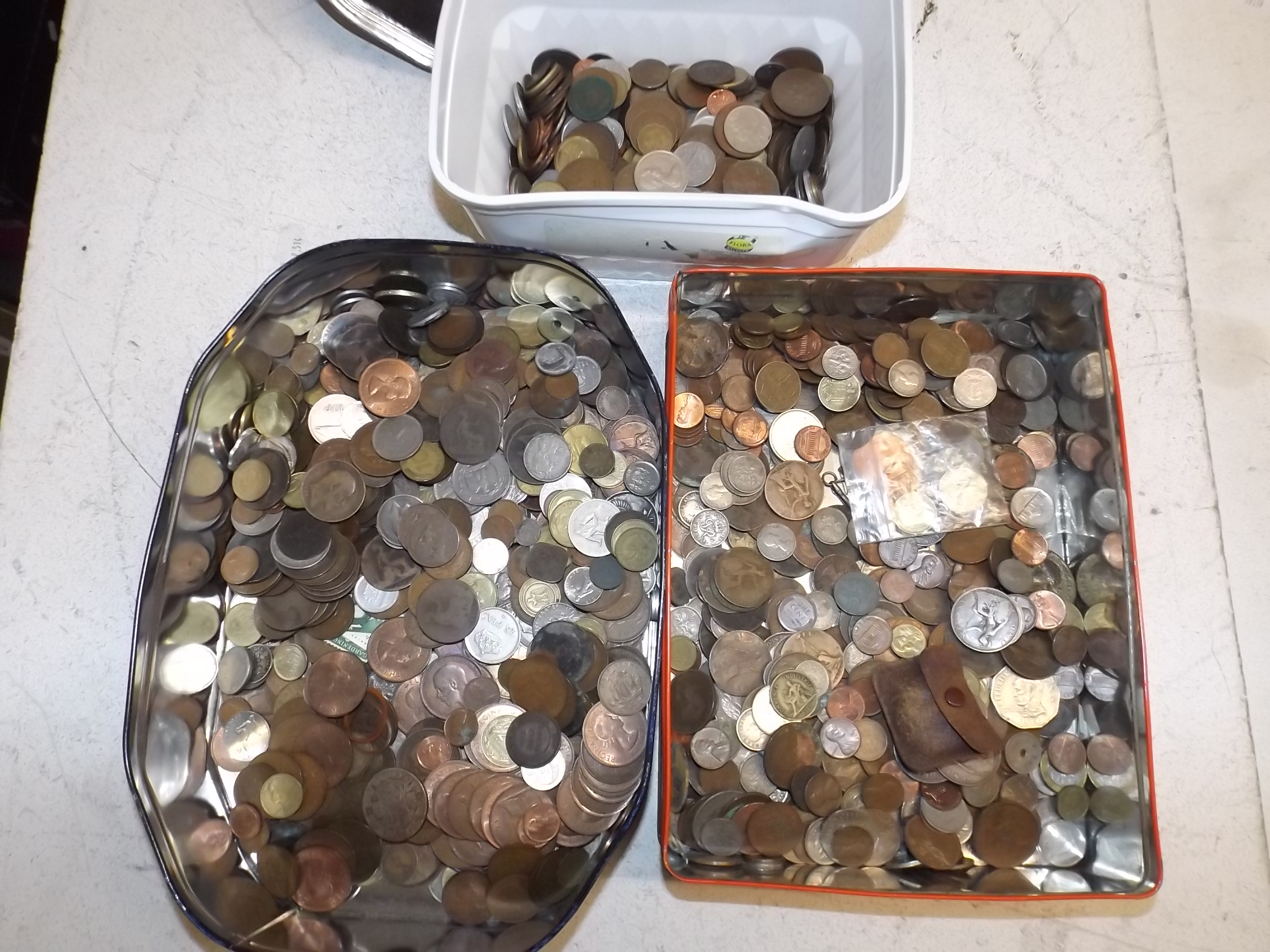 World coins in two tins and a plastic box.