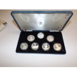 Queen Elizabeth the Queen Mother:- Seven crown size silver coins from various countries, cased.